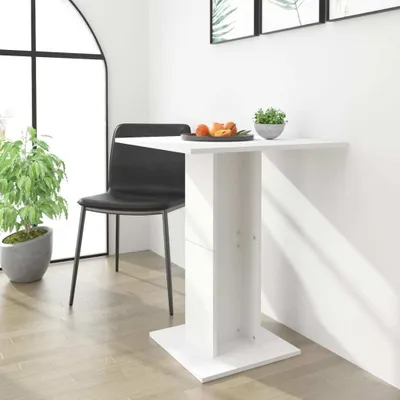 A white table with a chair next to a large window.