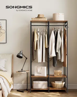 A bedroom scene with a SONGMICS wardrobe rack, clothing, and accessories.