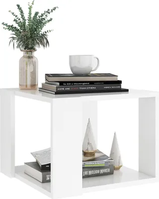 A white side table with books, a plant, and decorative items on it.
