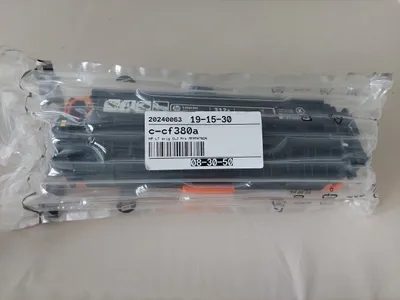 A sealed plastic package containing multiple black toner cartridges.