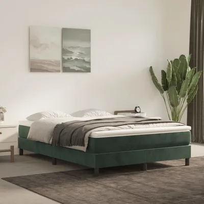 A bedroom scene with a bed, artwork, and a plant.