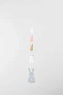 A garland of bunny-shaped ornaments hanging against a plain background.