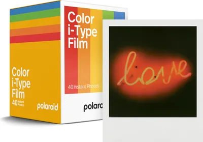 A box of Polaroid i-Type color film and a sample photo with the word 'love' in neon.