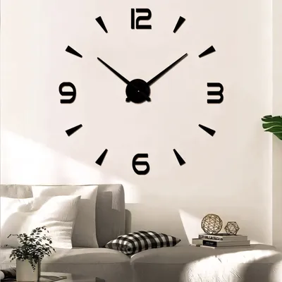 A large wall clock is mounted on a white wall above a sofa in a living room.