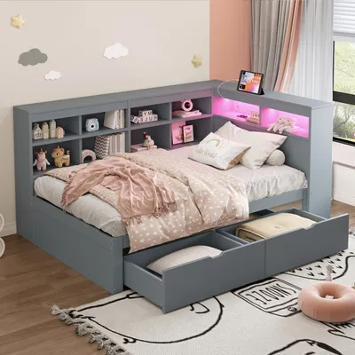 A child's bedroom with a grey daybed, shelves, and storage drawers. The bed is made with pink and white bedding, and there are decorative clouds and stars on the wall.