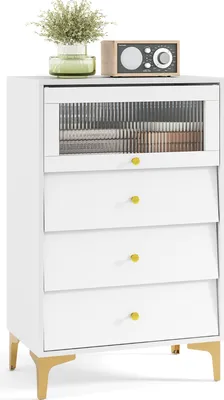 A white chest of drawers with a fluted glass door and gold legs, decorated with a plant and a radio on top.