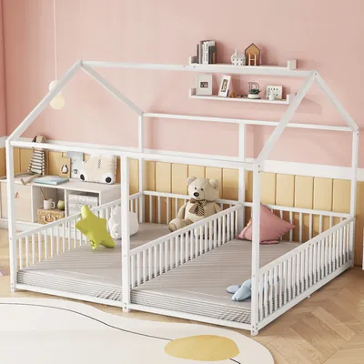 A child's house-shaped bed with two mattress areas and safety rails, decorated with stuffed animals and pillows.