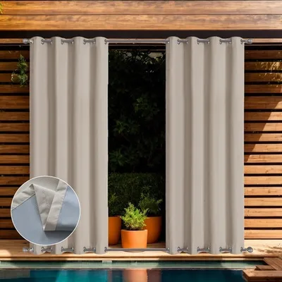 Outdoor curtains hanging on a wooden deck next to a swimming pool.