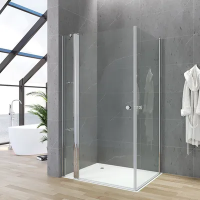 A modern bathroom with a glass shower enclosure, bathtub, and plant.
