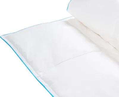 A close-up view of a white duvet with blue piping on a white background.