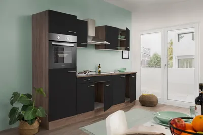 A modern kitchen setup with black cabinets and wood accents, featuring an oven and countertop.