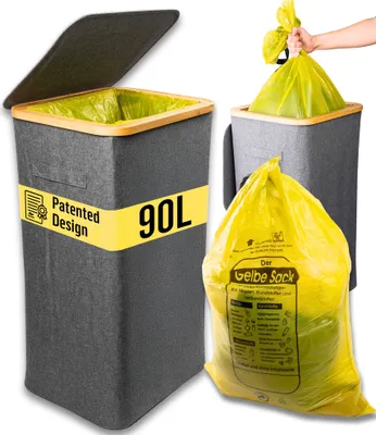 A trash can with a lid and a yellow trash bag being held by a hand.