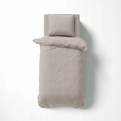A top-down view of a beige duvet cover and pillow on a white background.