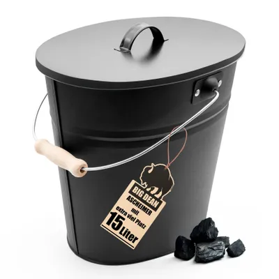 A black oval ash bucket with a lid and handle, placed on a white background with a few pieces of coal next to it.