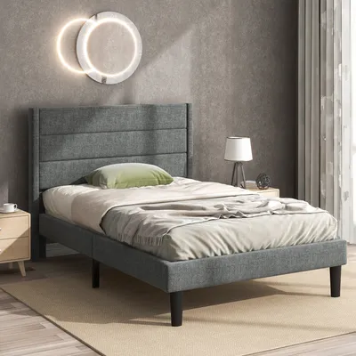 A bedroom scene with a bed, nightstand, and lamp.