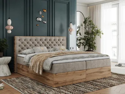 A bedroom scene with a large bed as the focal point, decorated with pillows and a throw blanket. The room features dark teal walls, a large window with sheer curtains, and a tall potted plant.