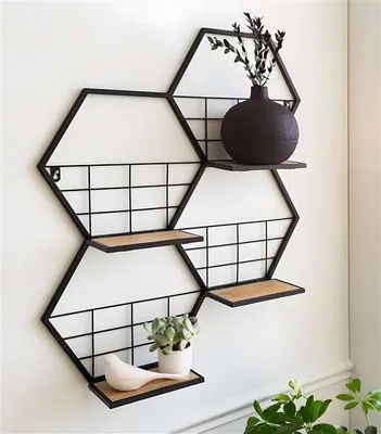 A hexagonal metal shelf unit mounted on a white wall, decorated with a vase, a plant, and a bird figurine.