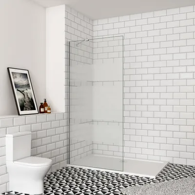 A modern bathroom with a toilet, a walk-in shower, and tiled walls and floor.