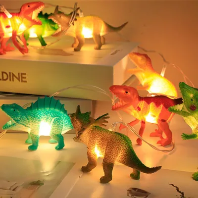 A collection of dinosaur-shaped string lights, illuminated from within, arranged on a surface.