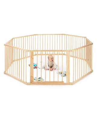 A baby is playing inside a wooden playpen.