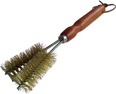 A grill brush with a wooden handle and brass bristles, isolated on a white background.