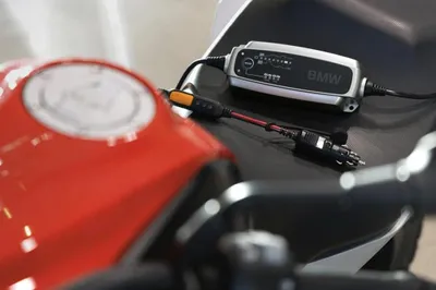 A BMW motorcycle battery charger is connected to the motorcycle.