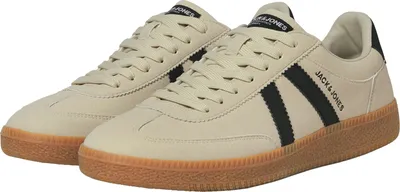 A pair of beige sneakers with black accents and a brown sole.