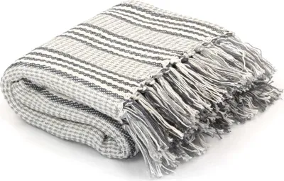 A folded throw blanket with fringe detail.