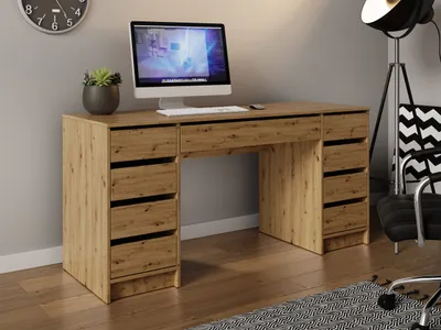 A wooden desk with a computer and drawers, set in a home office or bedroom environment.