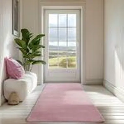A pink runner rug is laid out on a light wooden floor in a hallway, leading towards a glass-paneled door with a view of a green landscape. A white bench with a pink cushion and a potted plant are visible to the left.