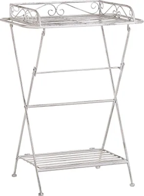 A white metal side table with two shelves and decorative scrollwork on the top shelf, shown against a white background.