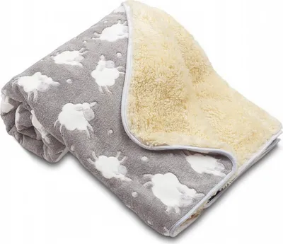 A folded baby blanket with a sheep pattern on one side and a fluffy cream-colored lining on the other.