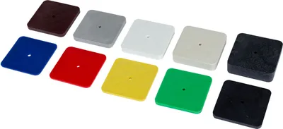 A collection of colorful square plastic shims arranged in two rows on a white background.