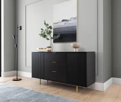 A modern living room with a black sideboard, a floor lamp, and abstract art on the wall.