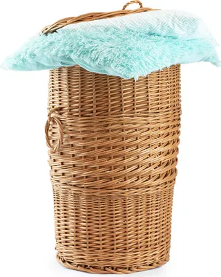 A wicker laundry basket filled with a blue and white patterned blanket and a fluffy blue blanket.
