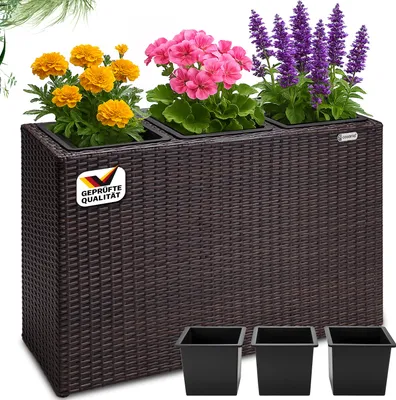 A brown rattan-style planter with three different types of flowers and three black pots below.