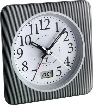 A close-up studio shot of a TFA Dostmann analog radio-controlled alarm clock with a temperature display.