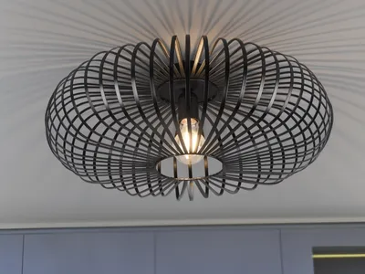 A black, modern ceiling light fixture with a cage-like design, casting shadows on a white ceiling.