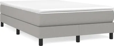 A studio shot of a mattress on a bed frame with black legs.