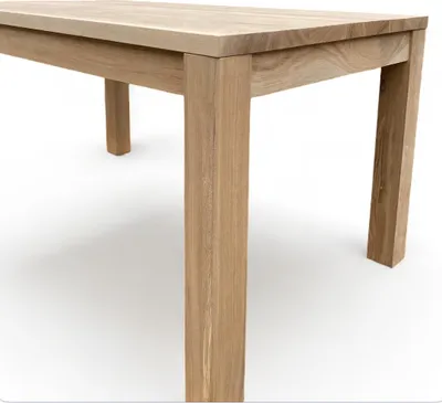 Close-up view of a wooden table leg and part of the tabletop, against a white background.