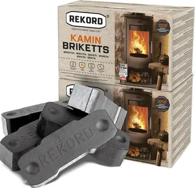 A product shot of Rekord Kamin Briketts with two boxes stacked and several briquettes in the foreground.