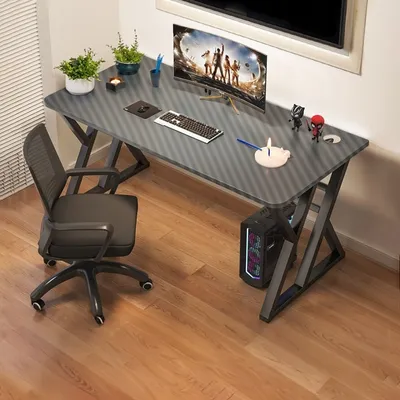 A gaming desk setup in a room with a computer, monitor, keyboard, and chair.