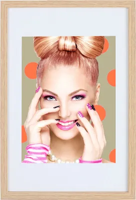 A woman with a large bow hairstyle and vibrant makeup poses with her hands near her face, against a background of large orange polka dots.