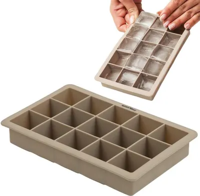 A silicone ice cube tray with 15 compartments, with a second tray filled with ice cubes being held by hands above it.