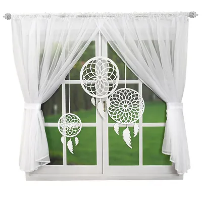 A window with white curtains and three white dreamcatchers hanging in front of it.