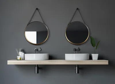 A modern bathroom vanity with two sinks and mirrors.
