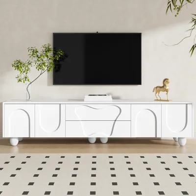 A white TV stand with a minimalist design is shown in a living room setting, with a TV mounted on the wall above it.