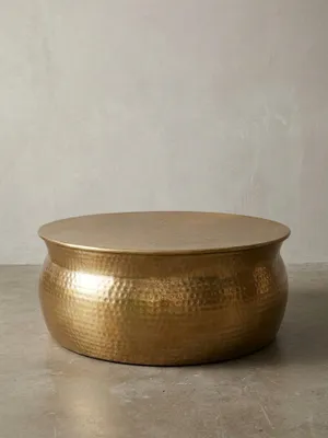 Runder Couchtisch aus Aluminium in Gold mit Hammerschlag-Optik, frontal auf weißem Hintergrund. Der 75x75x31 cm große Stubentisch überzeugt durch sein orientalisches Design._#sku_SAFWL5.453#