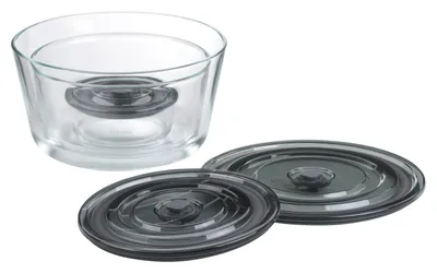 A glass bowl with two lids on a white background.