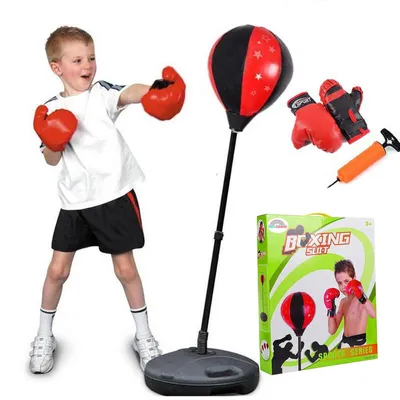 A young boy is shown punching a red and black boxing bag. The set includes boxing gloves and a pump. A box for the product is also visible.